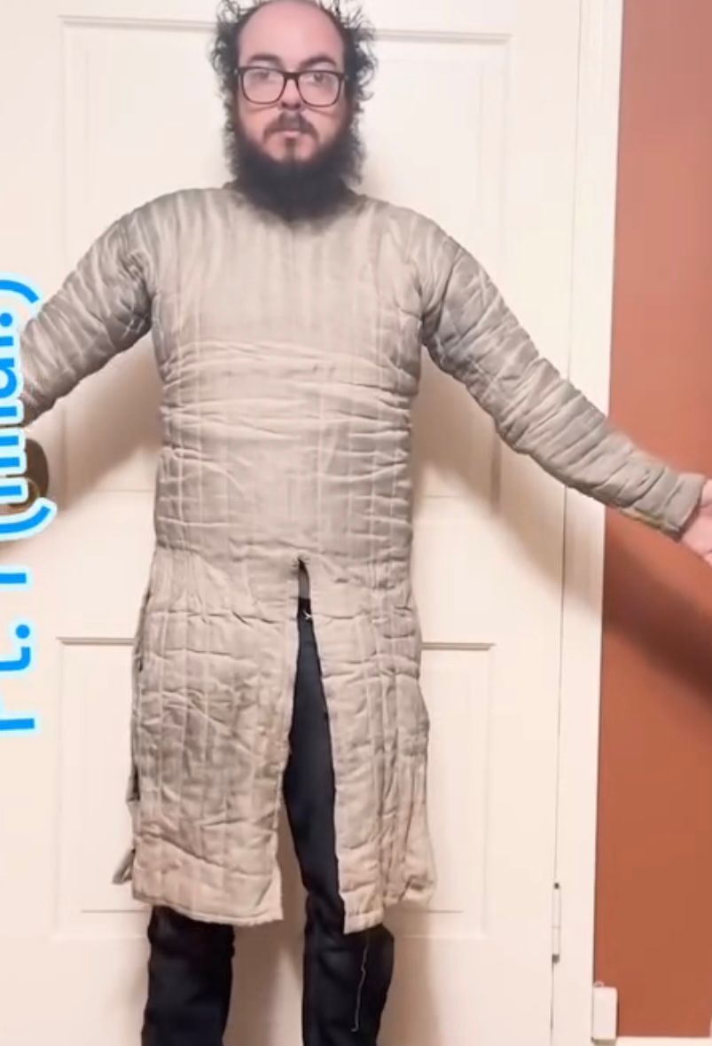 Nick, modeling a hand-made quilted gambeson made of undyed linen, stuffed with wool